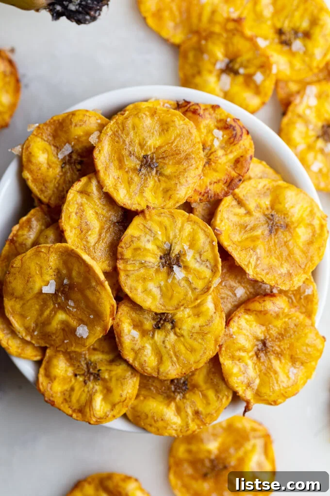 Tropical Plantain Crunch 7 A simple white bowl filled with golden, perfectly baked plantain chips.