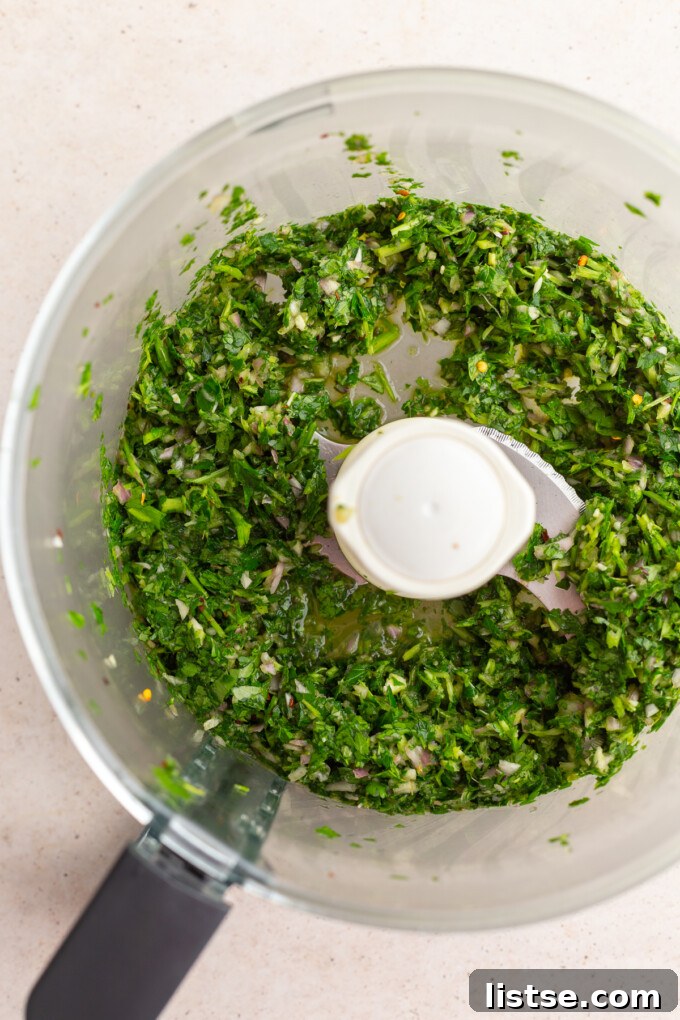 Zesty Argentine Chimichurri 6 Partially blended chimichurri ingredients in a food processor, showing coarse texture.