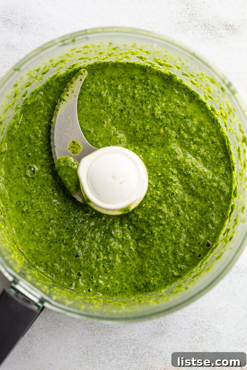 Zesty Argentine Chimichurri 7 A food processor blending green ingredients to create a smooth, vibrant chimichurri sauce.