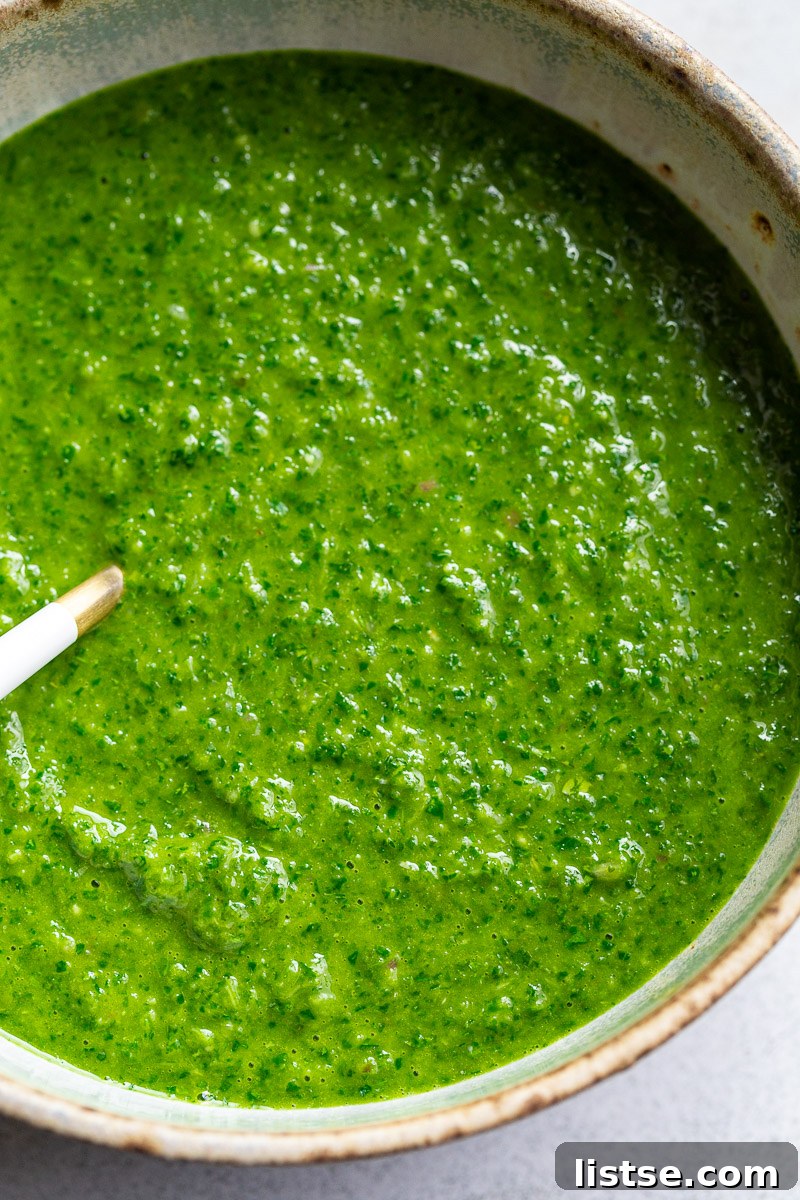 Zesty Argentine Chimichurri 9 A close-up of a bowl of vibrant green chimichurri sauce, highlighting its fresh texture and color.