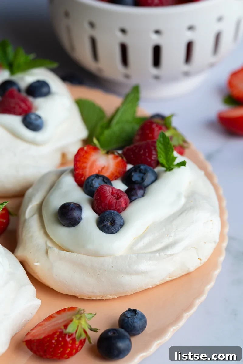 Fully assembled Pavlova with whipped cream and fresh berries