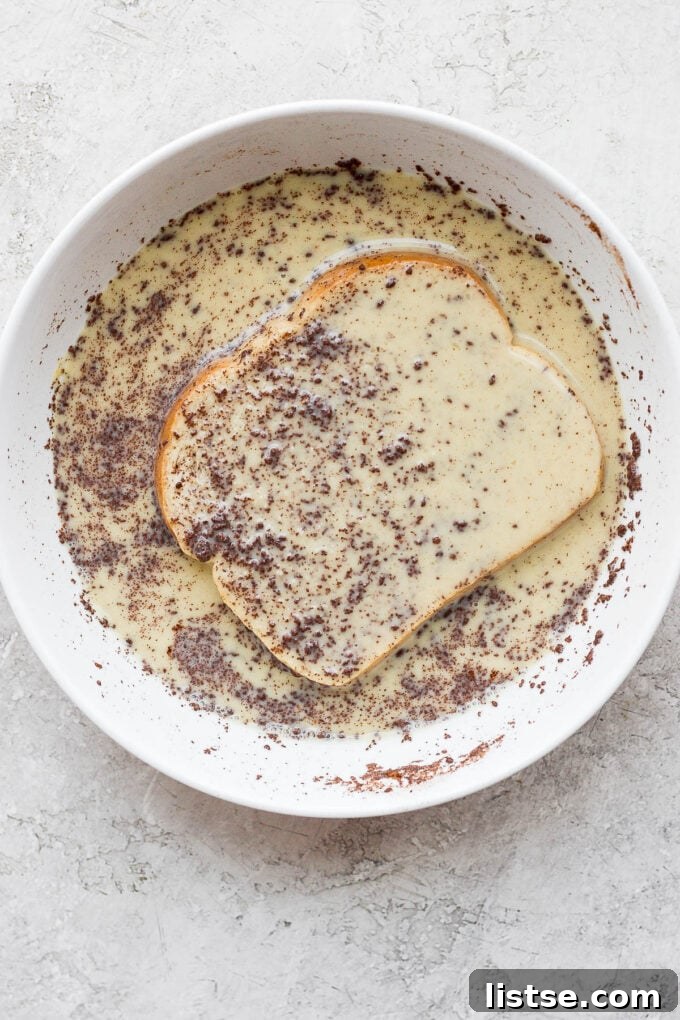 Soaking slice of bread in custard mixture.