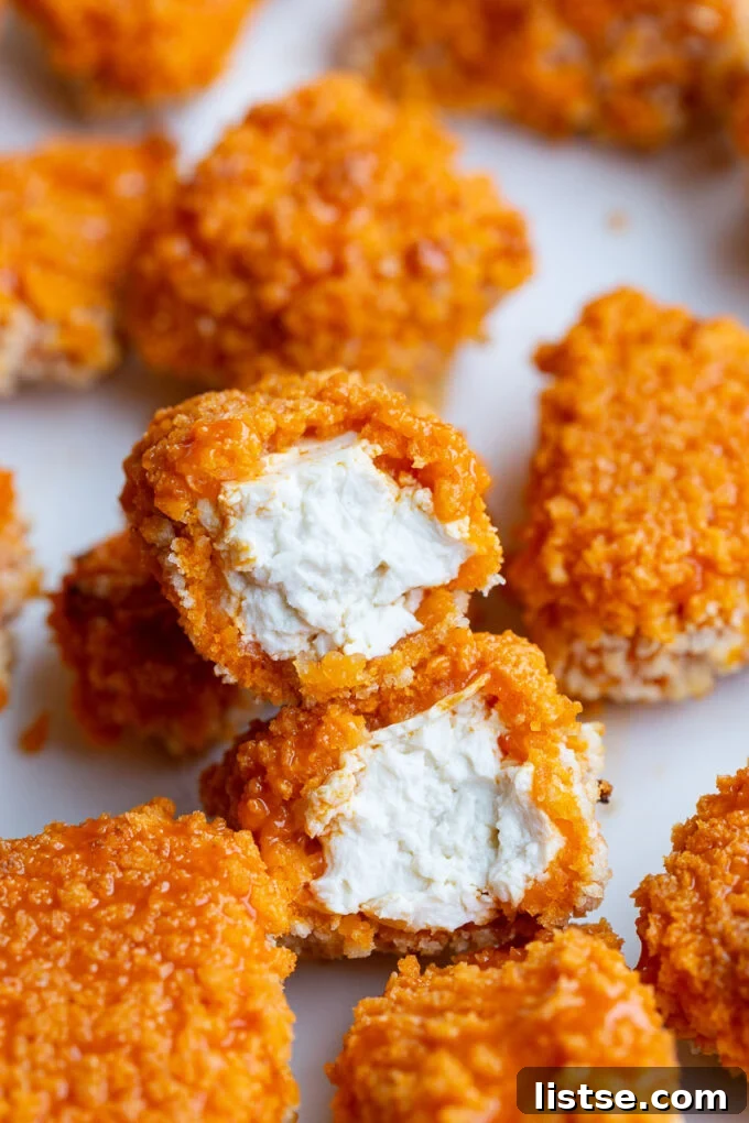 A perfectly cooked buffalo tofu nugget cut in half, revealing its tender inside.