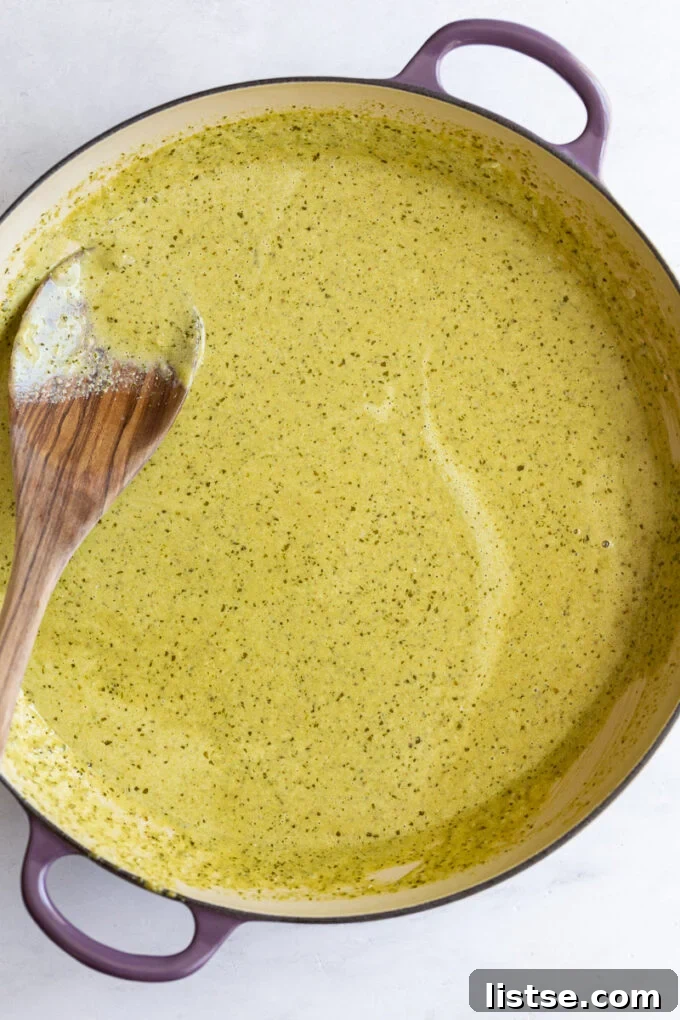 A large pot filled with creamy pesto sauce, ready to be tossed with pasta.