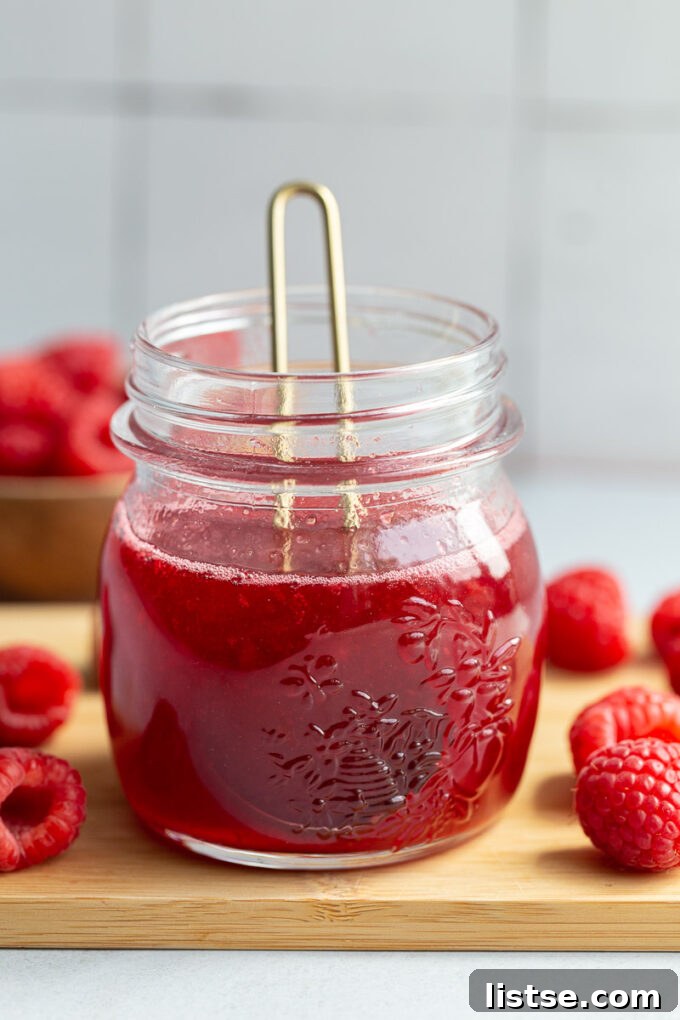 Raspberry syrup in a small glass jar.