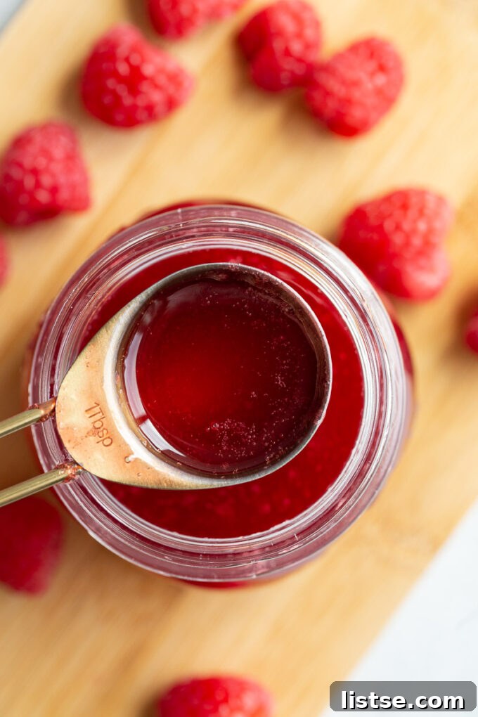 Serving raspberry juice from a small glass jar.