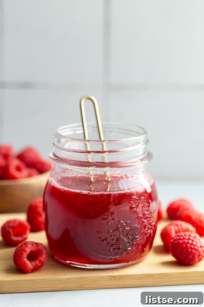A small glass jar of raspberry simple syrup.