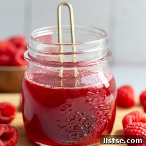 Raspberry syrup in a small glass jar.