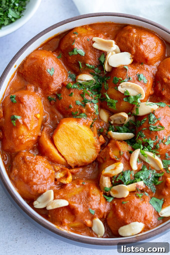 Golden-brown baby potatoes simmering in a rich, vibrant tomato-based sauce, ready to absorb all the delicious flavors.