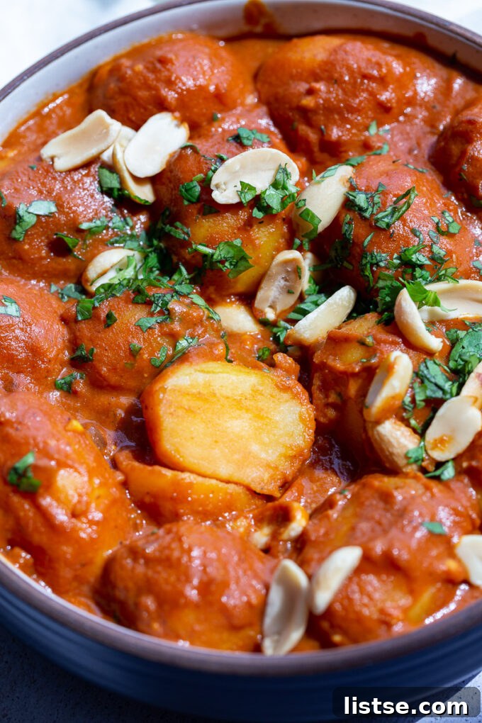 Close-up of a serving of Dum Aloo, highlighting the creamy sauce and tender potatoes, garnished with fresh cilantro.