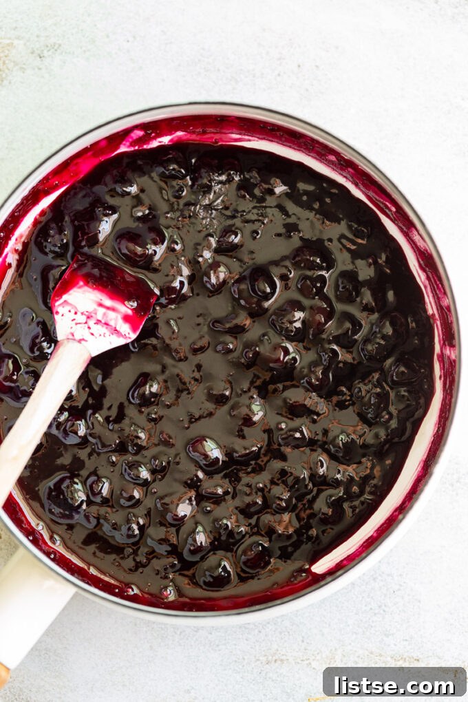 Sweet Blueberry Nectar 4 Blueberry syrup bubbling gently in a large pot on the stovetop, showing the cooking process.