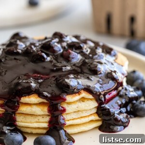 Blueberry syrup served over a stack of pancakes, illustrating the final dish.