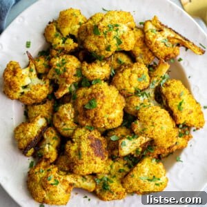 Curried cauliflower served in a white bowl, ready to eat.