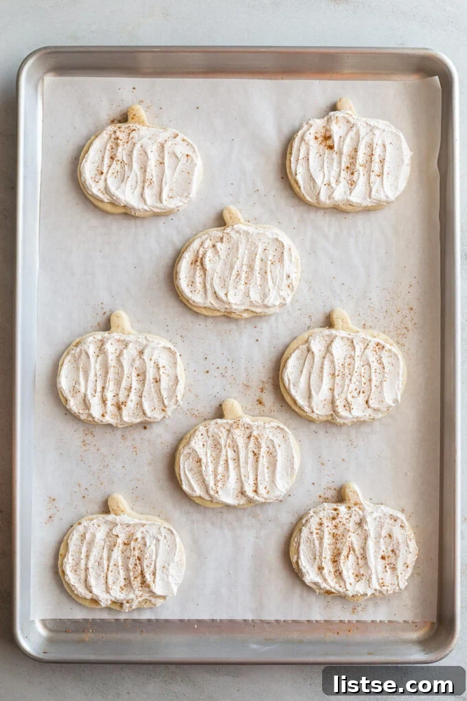 pumpkin shaped sugar cookies topped with a maple icing and sprinkled with nutmeg
