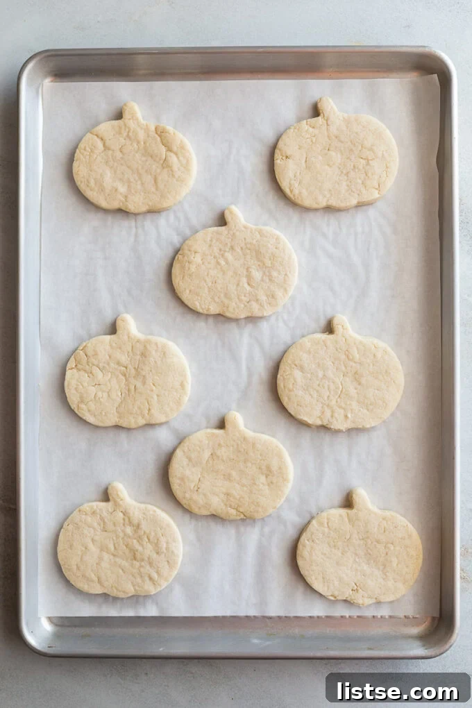 pumpkin shaped sugar cookies on a baking sheet