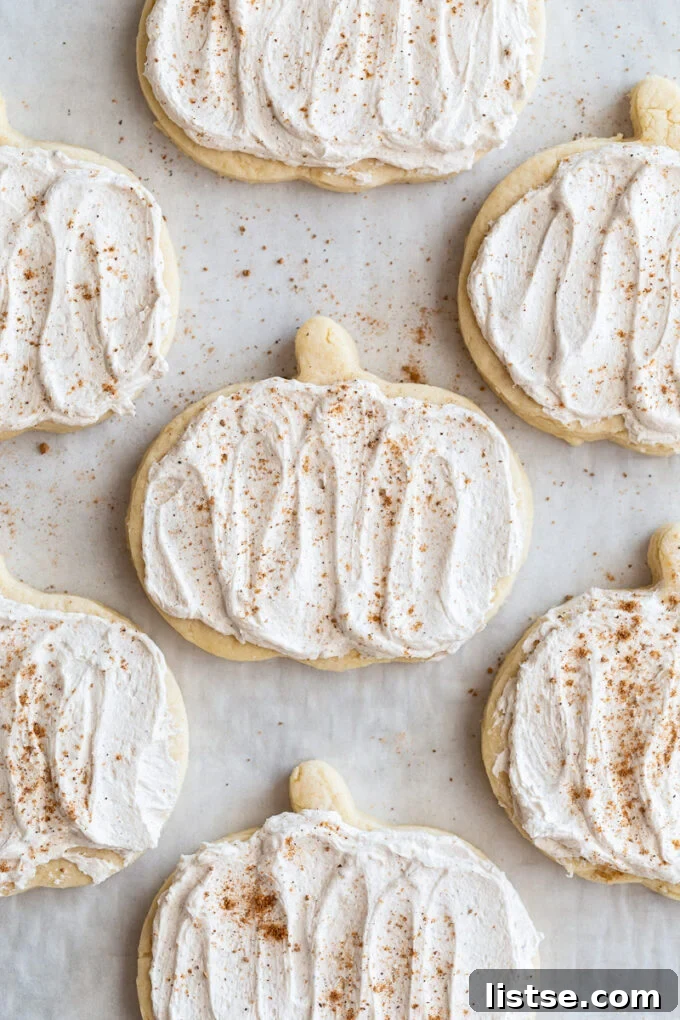 pumpkin shaped sugar cookies topped with a maple icing and sprinkled with nutmeg