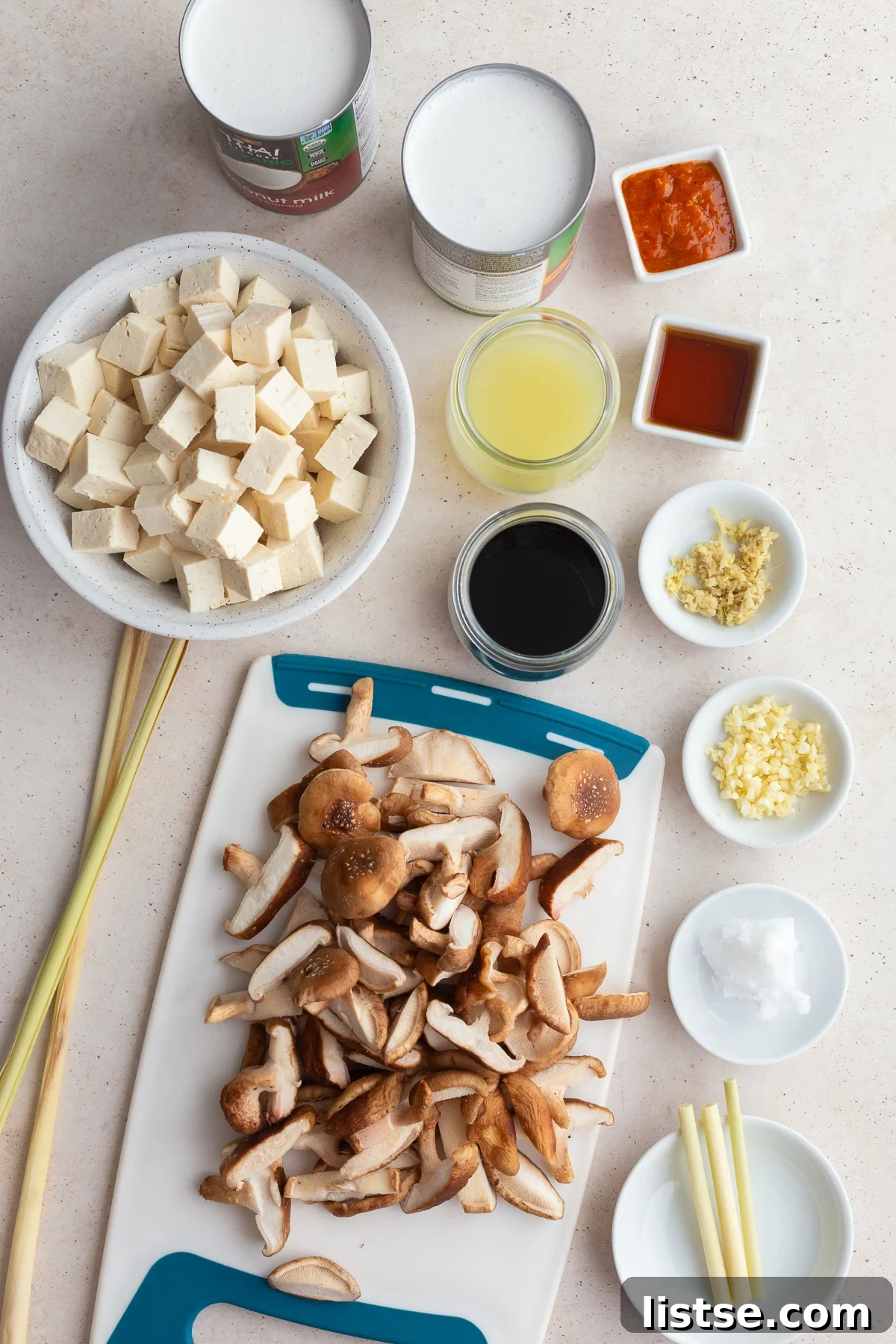 Velvety Coconut Tofu Comfort Bowl 4 An overhead shot showcasing all the fresh and vibrant ingredients neatly laid out on a wooden surface, ready to be used for making tofu soup.