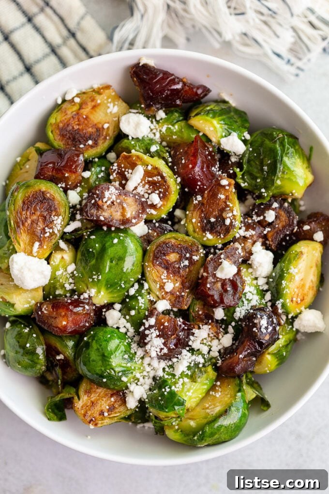 Close-up of golden-brown Date Sweetened Brussels Sprouts in a pan, with chopped dates and hints of garlic visible.