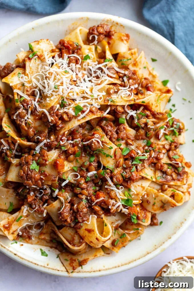 Hearty Lentil Bolognese 7 A generous serving of rich lentil pasta sauce over freshly cooked pasta in a white bowl, ready to be enjoyed.
