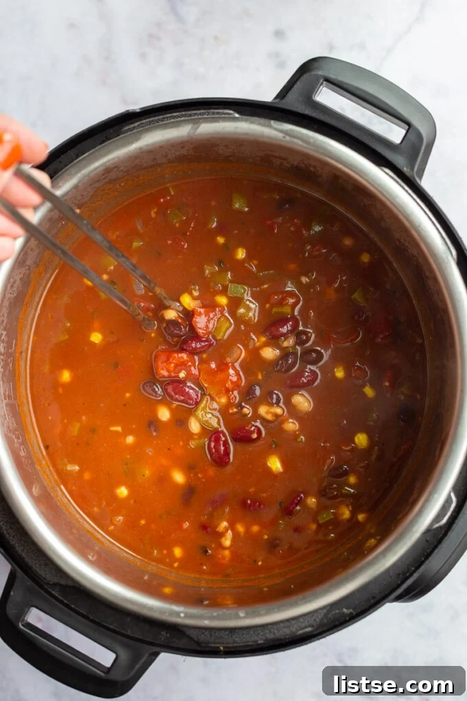 Ultimate Instant Pot Chili 4 Stirring chili in a pot.
