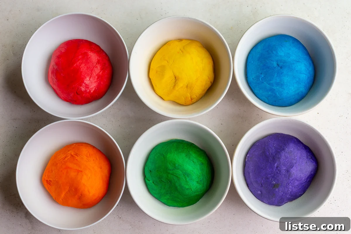 Kaleidoscope Loaf 7 Step 3: Six bowls of bread dough, each a different, vibrant color: red, yellow, blue, orange, green, purple.