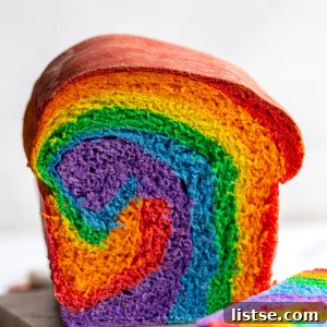 A slice of rainbow bread cut open, showing beautiful swirls of color.