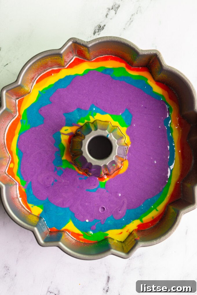 Kaleidoscope Bundt Cake 4 Rainbow cake batter layered in a bundt pan before baking.
