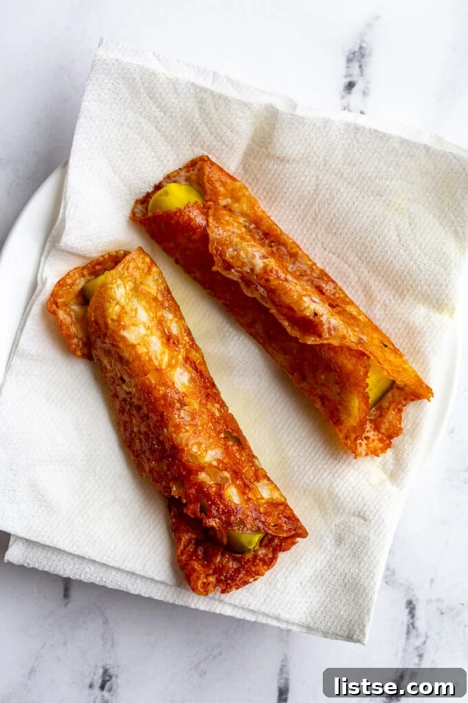 Freshly fried cheese pickle spears on a paper towel-lined plate to drain excess grease