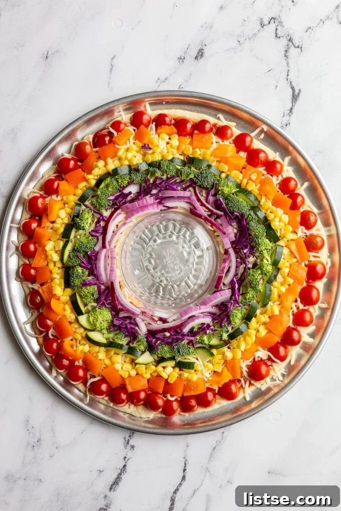 Vibrant Rainbow Pizza with a beautiful array of vegetables arranged by color.