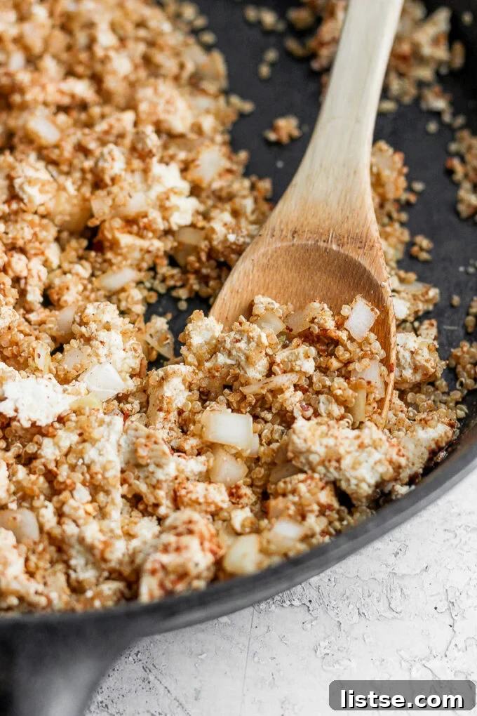 Zesty Quinoa Tofu Taco Crumbles 6 A close-up view of the skillet, filled with the rich, savory quinoa and tofu taco meat, perfectly cooked and garnished with fresh green herbs, with a serving spoon resting gracefully on the side, inviting a taste.
