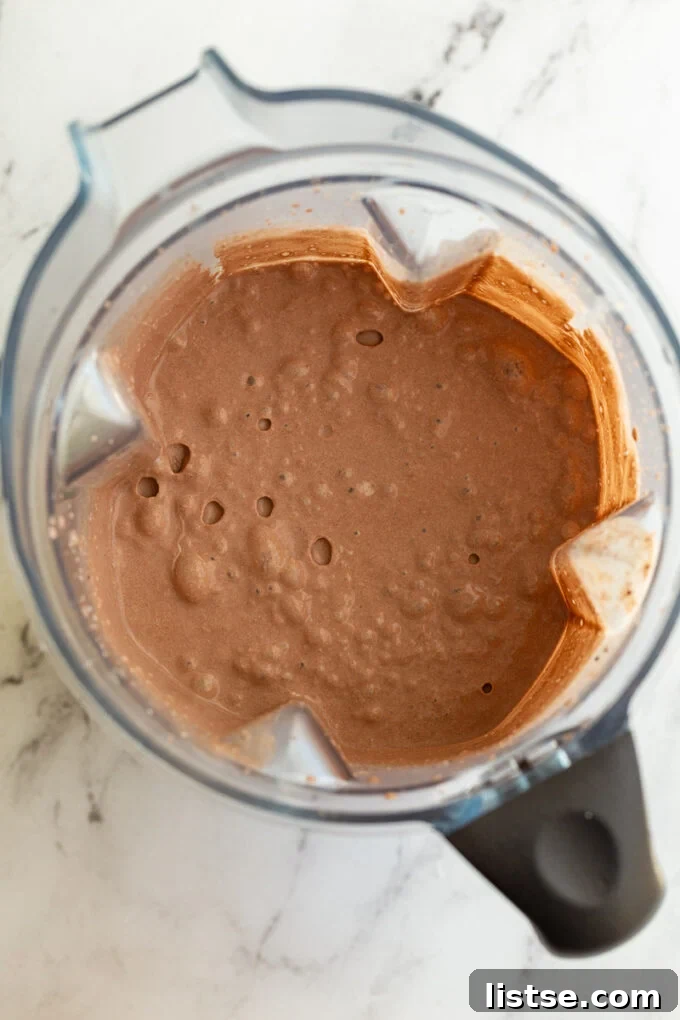 The smooth, liquid chocolate ice cream mixture in a blender, before being poured into the Creami pint for freezing.