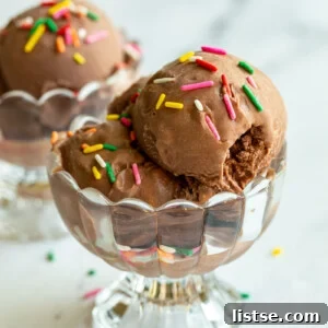 chocolate ice cream in a clear dish and topped with colorful sprinkles