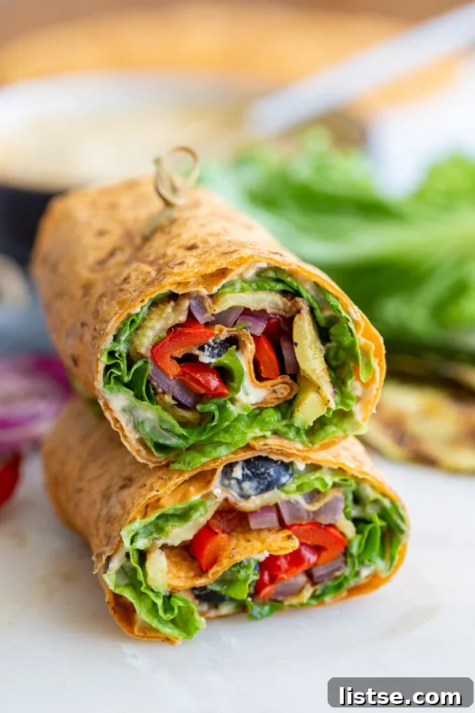 Close-up of grilled veggie wraps, halved and stacked, showing off the perfectly cooked vegetables and generous fillings.