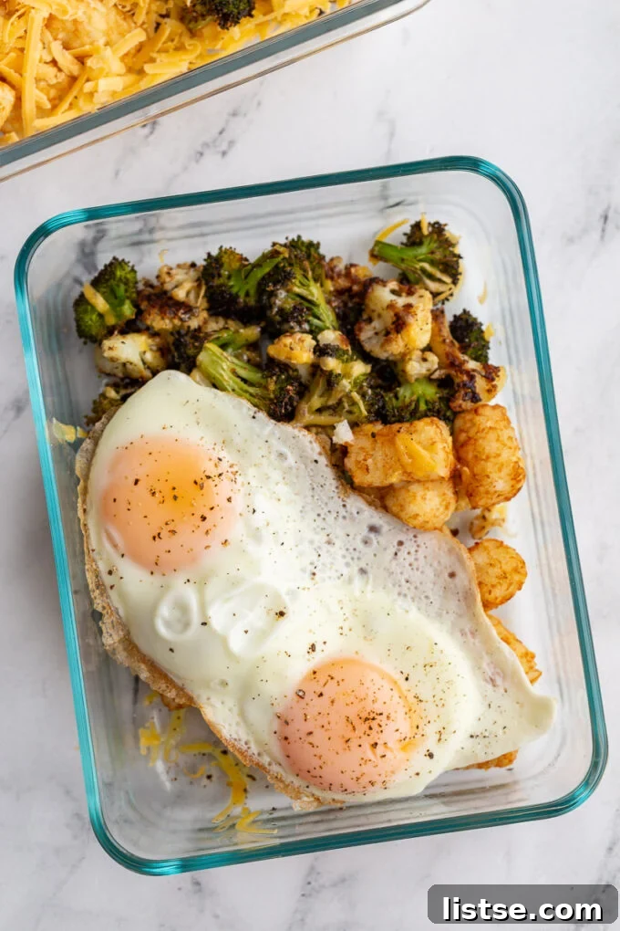Plant-Powered Breakfast Prep 2 A vibrant meal prep veggie breakfast bowl featuring roasted broccoli, cauliflower, tater tots, cheese, and a fried egg.