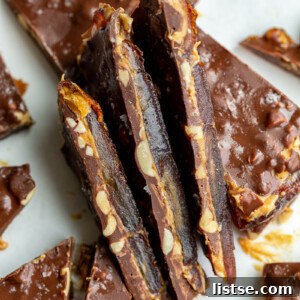 Finished date bark, showing three pieces stacked sideways to highlight the distinct layers of date, peanut butter, and chocolate.