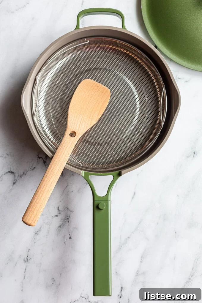 Green Always Pan with colander and wooden spoon inside, ready for cooking