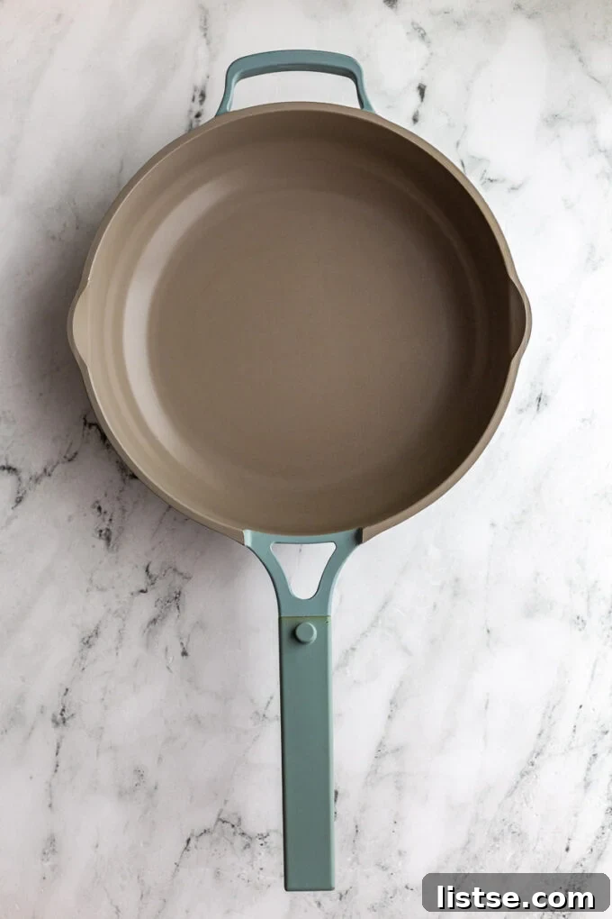 Blue Always Pan sitting on a marble board, highlighting its sleek design