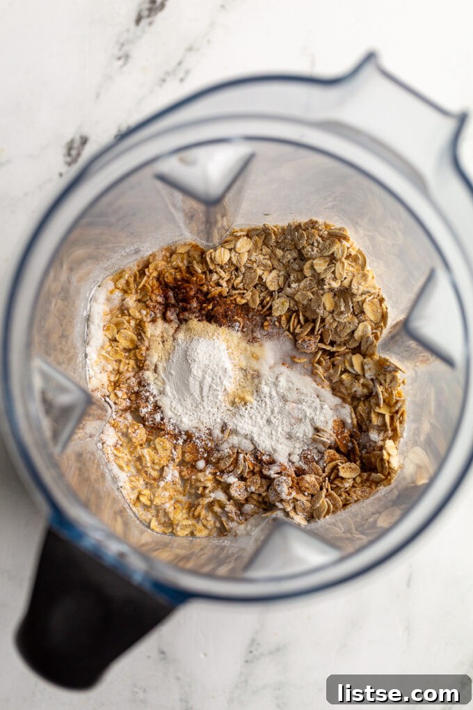 Ingredients in a blender: oats, vanilla, cinnamon, milk, and baking soda