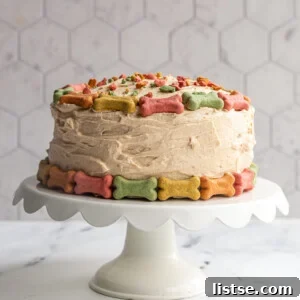 A festive round dog birthday cake covered in colorful mini bones with crushed bones on top as if they're sprinkles