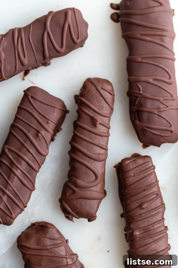 Chocolate Caramel Shortbread Bars 5 Overhead close-up of beautifully arranged homemade Twix chocolate bars, each adorned with a delicate swirl of extra chocolate on top, highlighting their homemade charm.