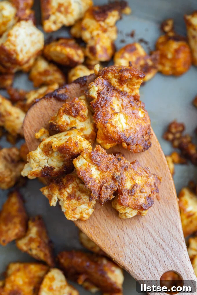 Close-up shot of seasoned chipotle tofu chunks in a skillet, sizzling and cooking to perfection.