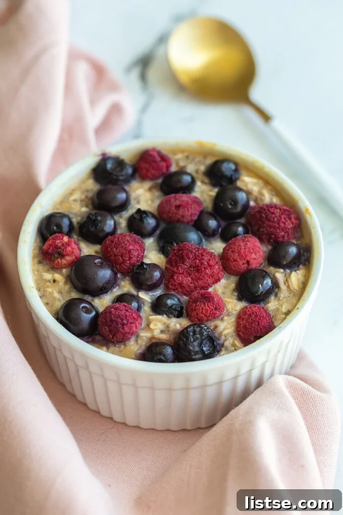 single serve baked protein oats in a ramekin and topped with fruit.