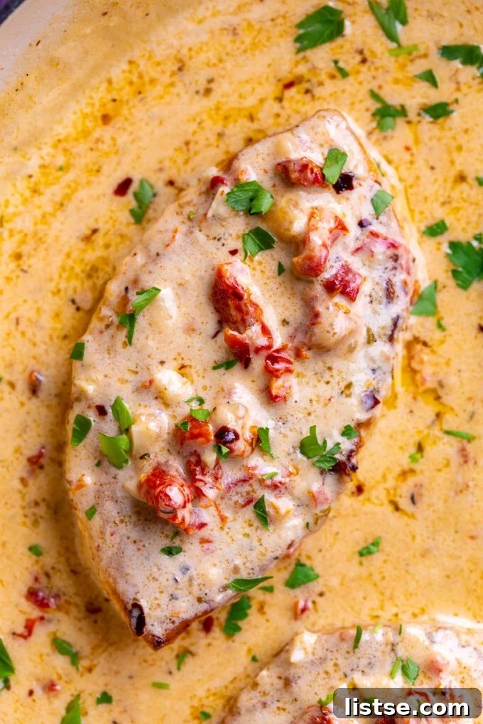 A skillet filled with golden-brown Marry Me Tofu pieces simmering in the creamy Tuscan sauce, garnished with fresh basil.