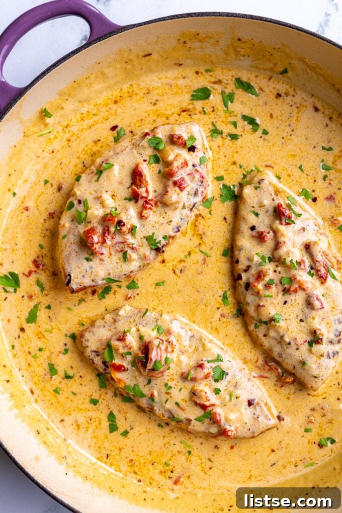 Three perfectly cooked Marry Me Tofu pieces in a skillet, coated in a thick, creamy Tuscan sauce, ready to be served.