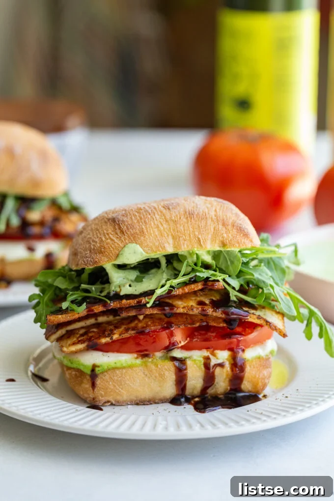 A close-up of a beautifully assembled Tofu Caprese Sandwich with fresh ingredients.