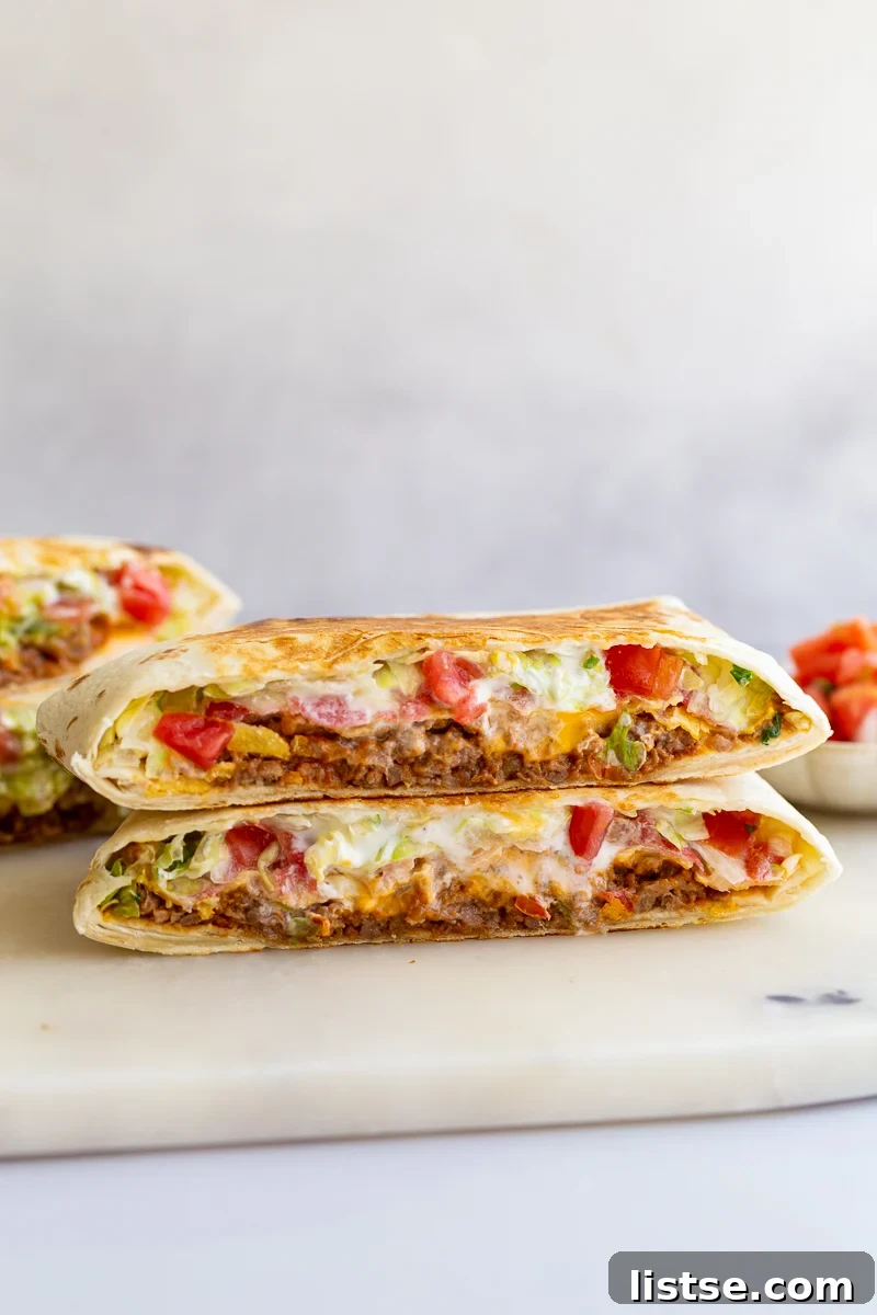 A stack of perfectly golden-brown vegan crunchwrap halves, showcasing the beautiful layers and inviting texture, ready to be enjoyed.