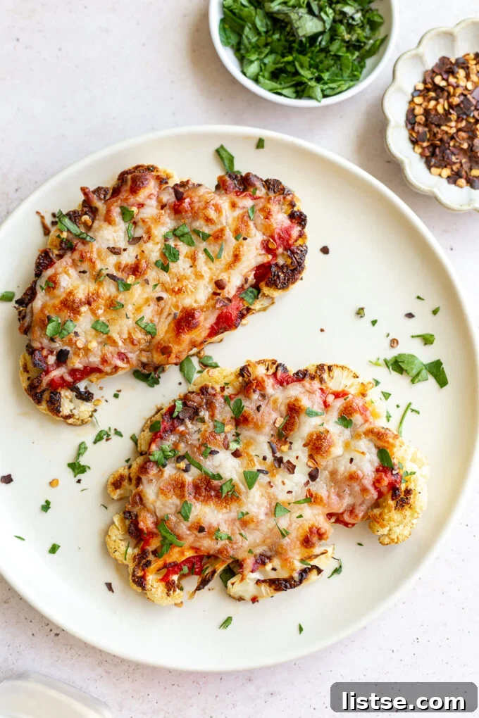 Golden Baked Cauliflower Parmesan 5 Garnishing cauliflower parmesan with fresh basil and red pepper flakes before serving.