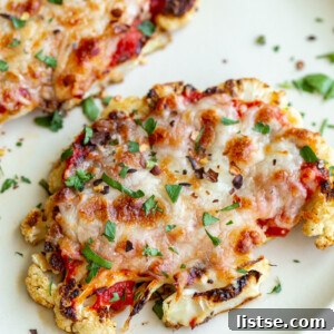 Golden Baked Cauliflower Parmesan 6 Cauliflower Parmesan: A close-up of a baked cauliflower steak topped with marinara and melted cheese.