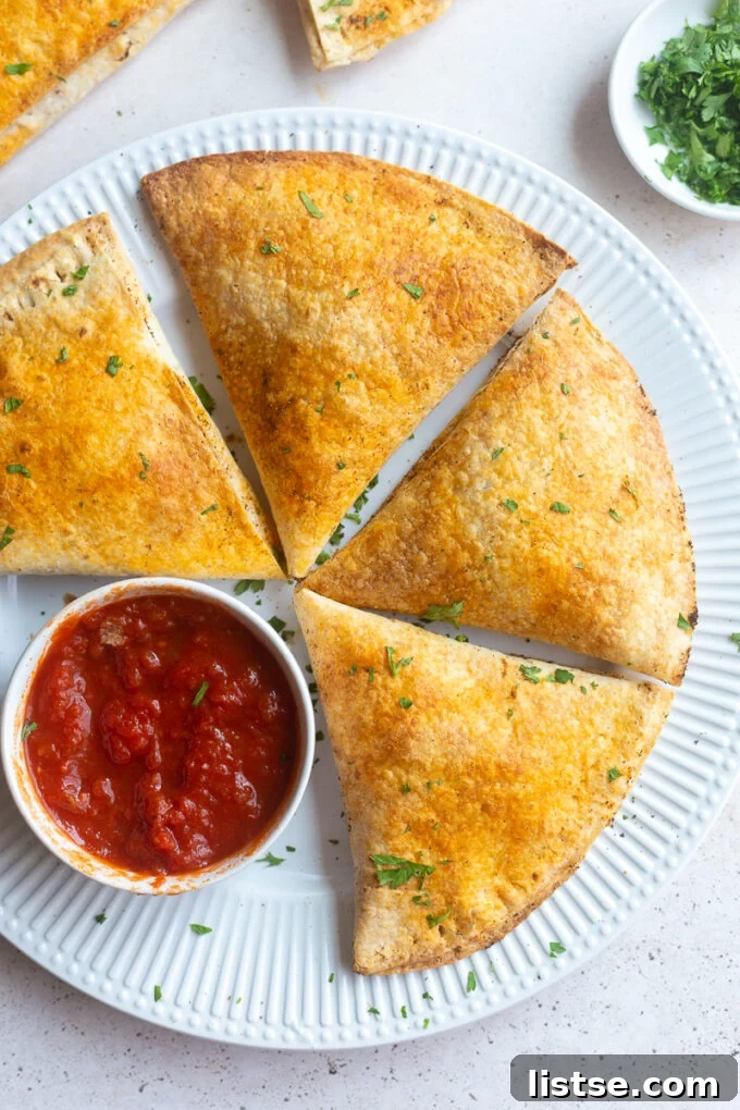 Freshly baked homemade pizza pockets, golden brown and ready to eat, scattered with herbs.