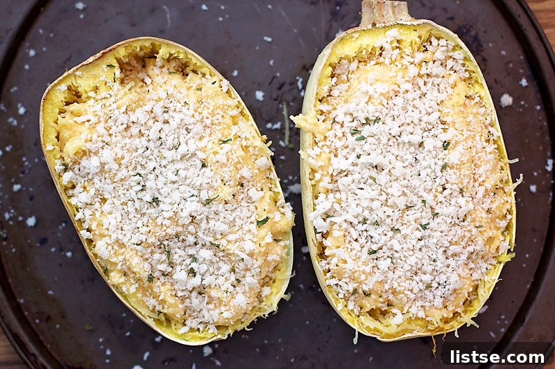 A whole, roasted spaghetti squash, split open to reveal its tender, noodle-like strands, ready for the cheesy filling.